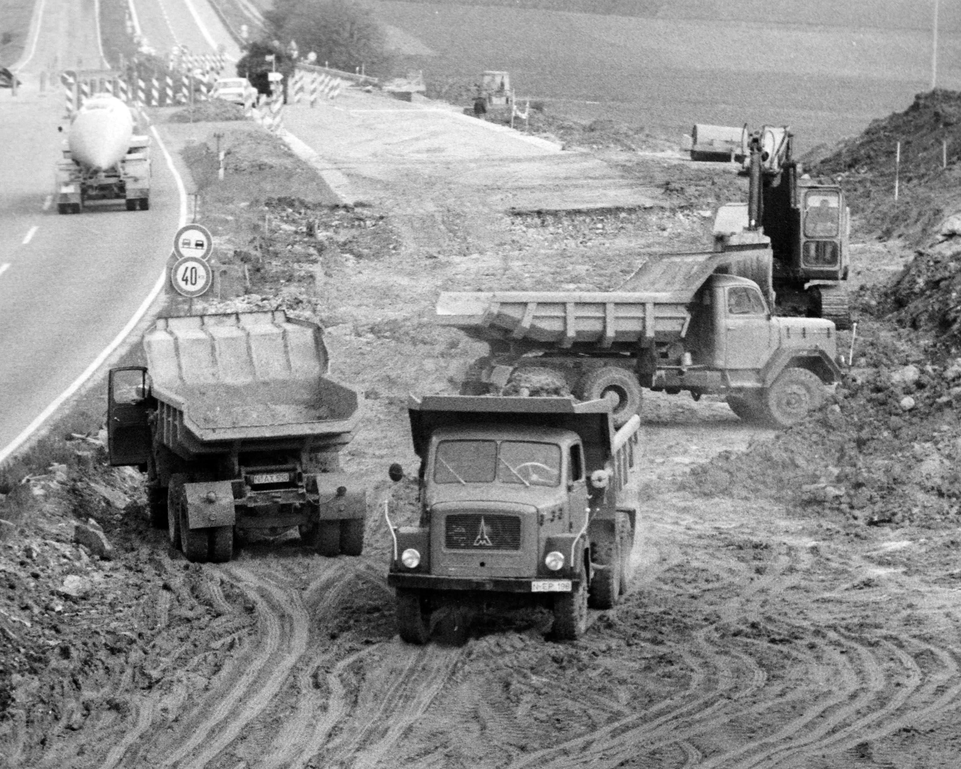 Immer wieder müssen auf der Autobahn die Fahrbahnen erneuert werden. Das war auch 1968 schon so, als etwa auf der A9 bei Pegnitz nicht nur die Teerdecken repariert werden mussten, sondern zusätzlich auch noch eine Standspur angelegt worden ist. Dafür waren erhebliche Eingriffe in die Landschaft nötig, auch mehr als 100 Bäume mussten gefällt werden. Den ganzen Sommer über waren über 100 Arbeiter tätig, die Kosten betrugen damals fünf Millionen D-Mark. Mitten im Bild macht sich ein schwerer Eckhauben-Lkw von Magirus-Deutz nützlich.