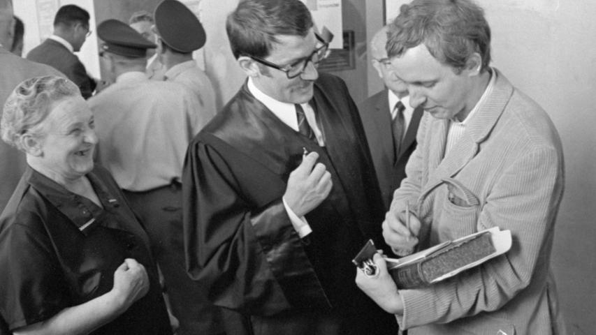 Horst W. Blome (rechts) gibt an der Seite seines Rechtsanwaltes an der Tür zum Gerichtssaal noch Autogramme.  Hier geht es zum Kalenderblatt vom 11. Juli 1968: Blome durfte sitzen"