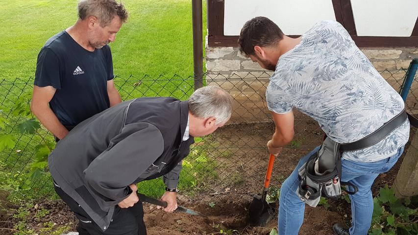 Am Zaun zum Nachbarsgrundstück hilft Vermessungsoberwart Michael Wolkersdorfer (re.) den Feldgeschworenen beim Graben.