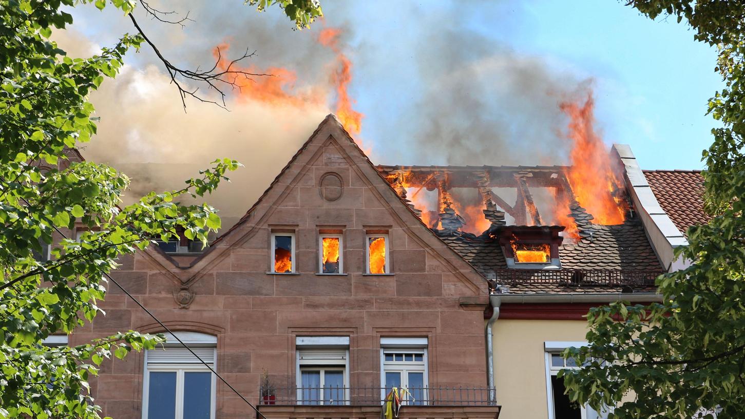 Die Flammen schießen aus dem Dachgeschoss des Mehrfamilienhauses.