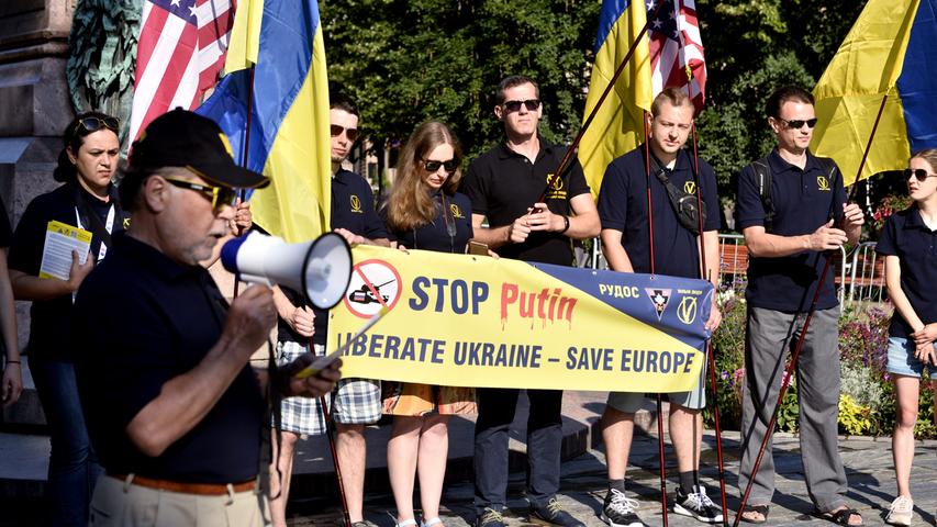 Stop Putin Liberate Ukraine - Save Europe" (Stoppt Putin Befreit die Ukraine - Rettet Europa) steht auf dem Banner von Aktivisten bei einem Protest gegen den Gipfel.