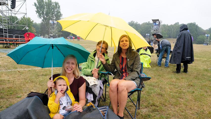 Mit Schirm, Charme und Campingstuhl: Eisernes Lächeln hilft gegen Regen.