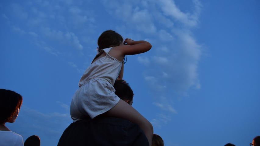 Eine junge Besucherin schaut auf der Pfaffengrunder Terasse in der Bahnstadt durch ein Fernglas in den Himmel. Bei der längsten Mondfinsternis des 21. Jahrhunderts taucht der Mond in den Erdschatten ein.