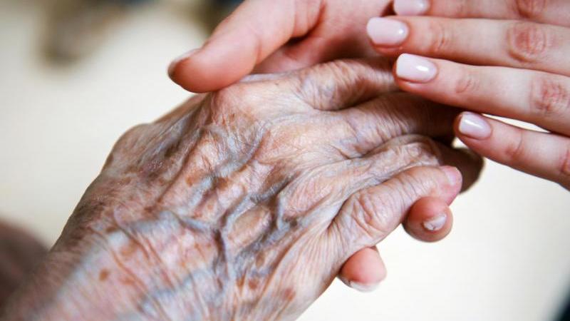 Eine Pflegerin hält die Hand einer alten Frau. Der Pflegenotstand macht vielen Menschen Sorge.