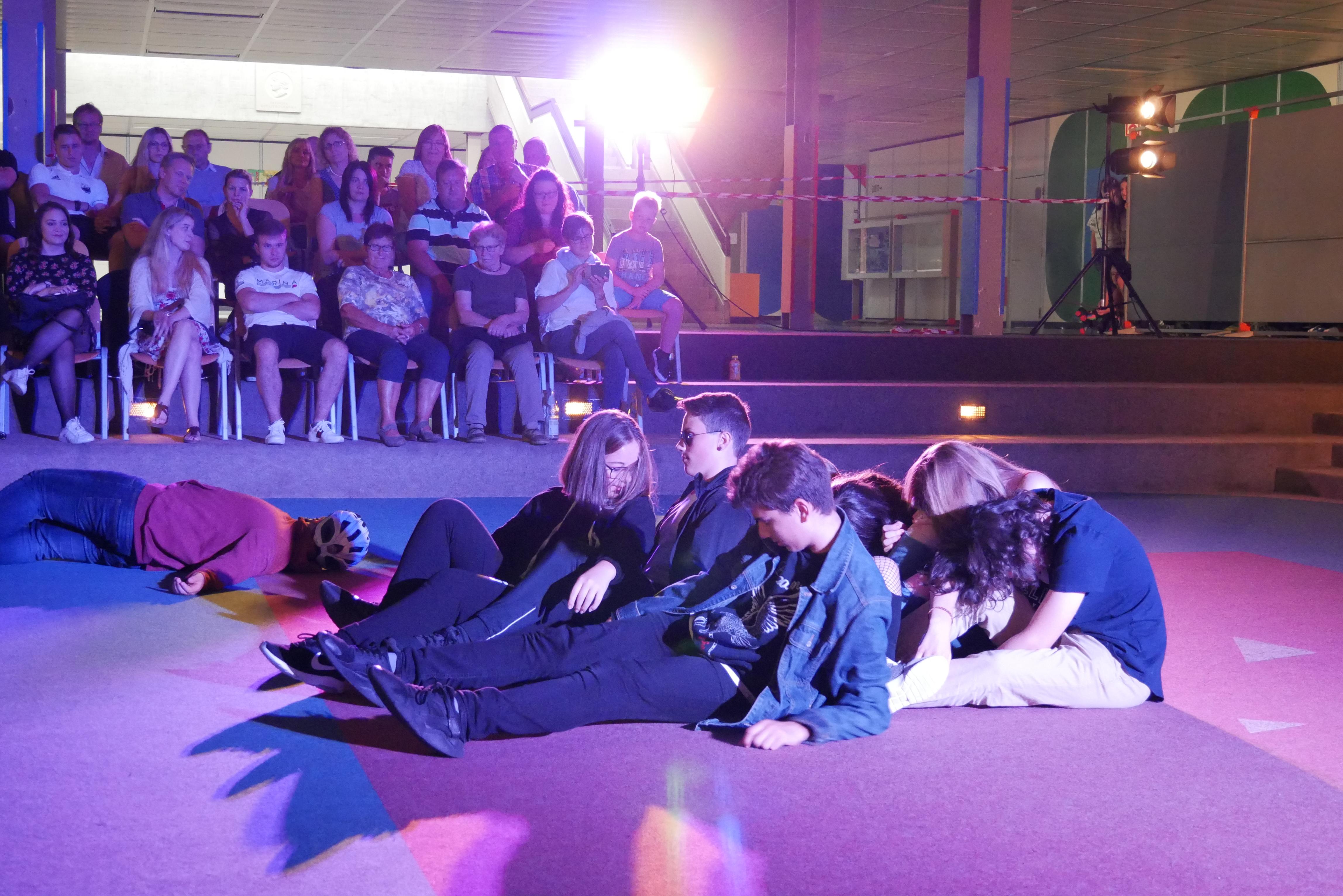 Fast 200 Zuschauer erlebten in der letzten Schulwoche die neueste Produktion der Theatergruppe der Senefelder-Schule. 41 Schülerinnen und Schüler aller Schularten hatten in Eigenregie das Stück „The weed on the other side“ (Das Gras auf der anderen Seite) entwickelt, in Anlehnung an den „Revolution Train“, den Drogenpräventionszug, der im letzten Oktober auch für einen Tag am Weißenburger Bahnhof Station gemacht hat, die Drogenkarriere junger Menschen schildert und von vier Klassen der „Sene“ besucht worden ist. Die Schauspielerinnen und Schauspieler beeindruckten durch sehr gute Umsetzung des problematischen Stoffes. Mit Ausnahme einer Toneinspielung bei der Disco-Szene wurden auch schwierige Passagen, wie z.B der Unfall, bei dem ein Radfahrer vom angetrunkenen Autofahrer tödlich verletzt wird, pantomimisch dargestellt. Großer Applaus belohnte die Leistung der jungen Schauspieltruppe. Beim dreitägigen Schultheaterfestival in Ingolstadt, bei dem das Stück zwei Mal aufgeführt wurde, fand es ebenfalls großen Anklang.