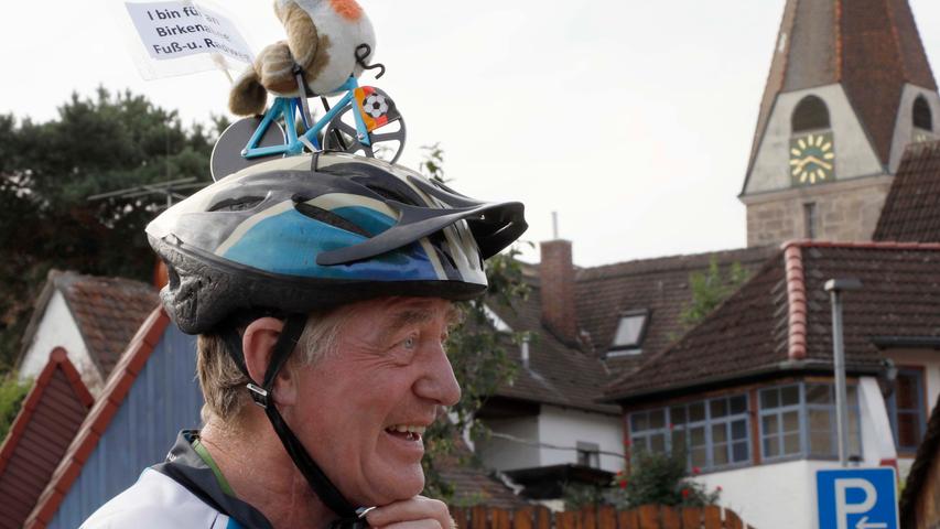 Der Mann hat einen Vogel auf dem Rad auf dem Helm.