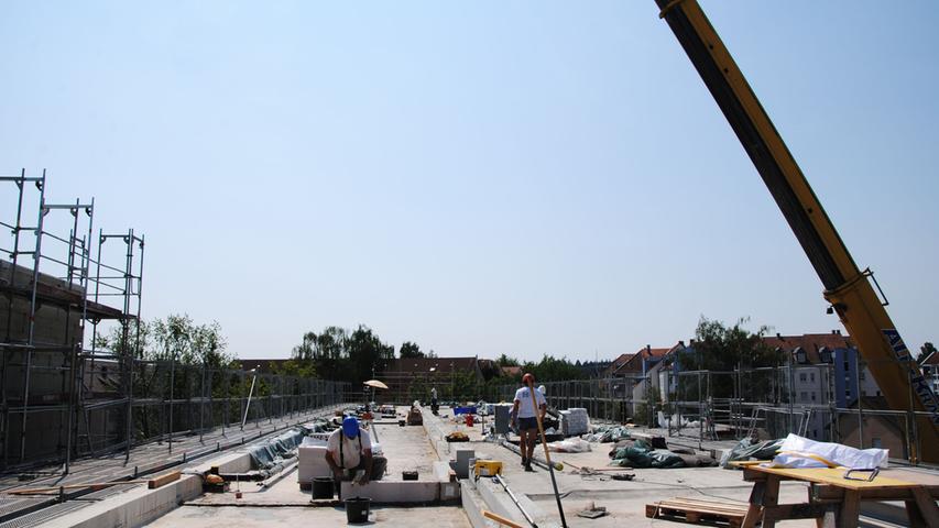 Auf dem Dach brütet die Hitze: Bauarbeiter trotzen auf dem Dach eines Mietshauses in der Konrad-Adenauer-Straße der Hitze.
