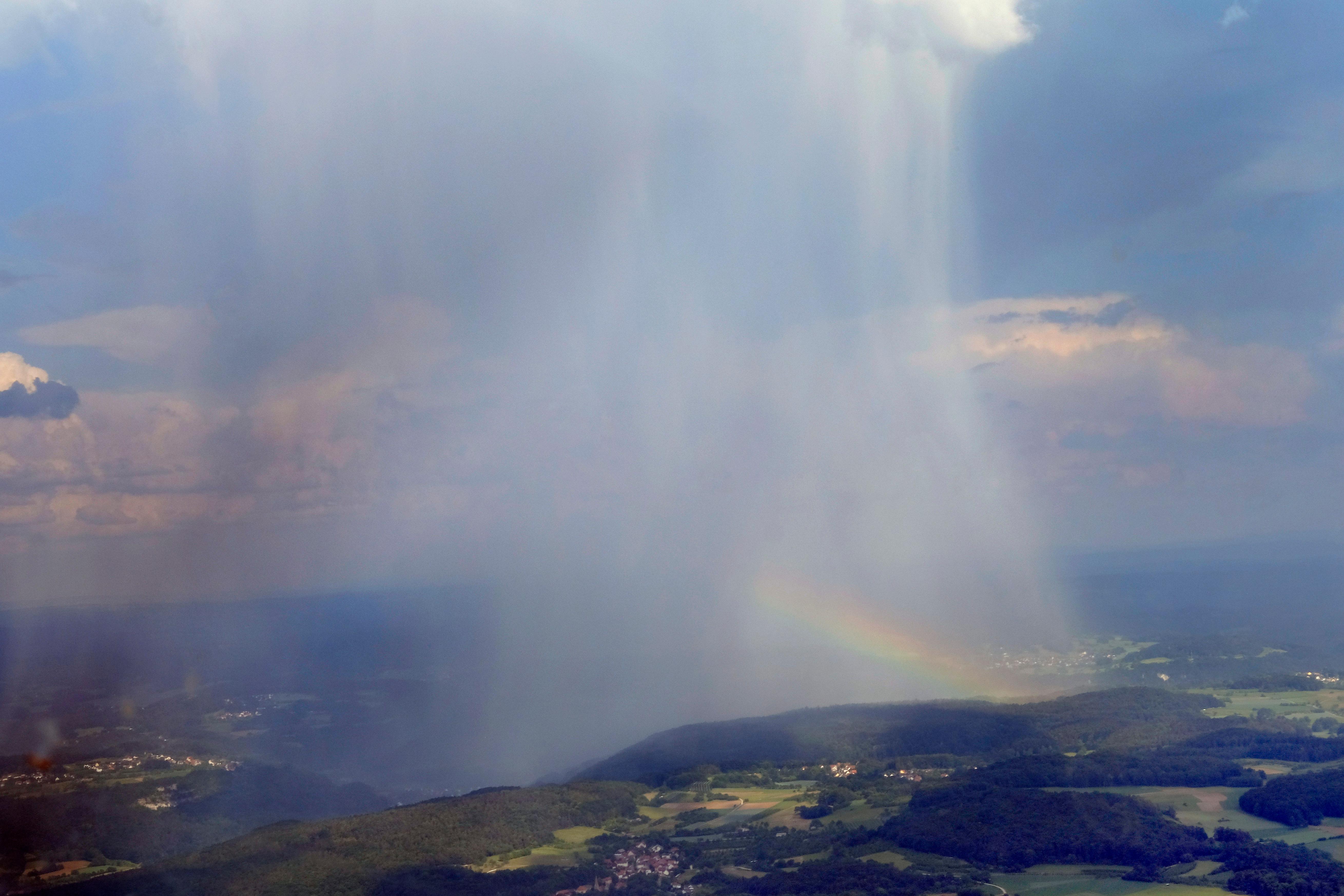 Hier zu sehen ist eine Regenfront und ein Regenbogen über der Fränkischen Schweiz - und zwar sicher aus dem trockenen Flugzeug aus. Für die Menschen unten auf der Erde war der Anblick wohl ein wenig unerfreulicher als für unseren Fotografen.
