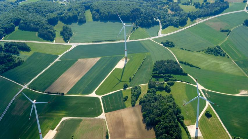 Beim Vorbeifahren wirken die Windräder riesig und majestätisch - vom Flugzeug aus betrachtet könnten es allerdings Spielzeuge sein. Dieses Luftbild zeigt Windenergieanlagen in der Region Nürnberg.