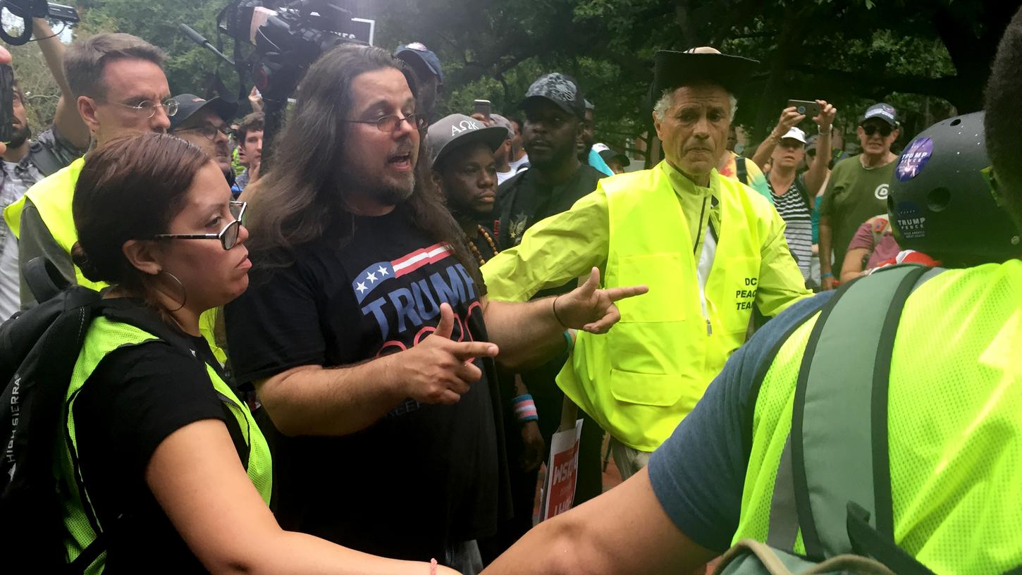 Ein Trump-Unterstützer wird während einer Demonstration gegen einen rechtsextremen Aufmarsch vor dem Weißen Haus zum Jahrestag der tödlichen Proteste in Charlottesville von Sicherheitskräften abgesichert.