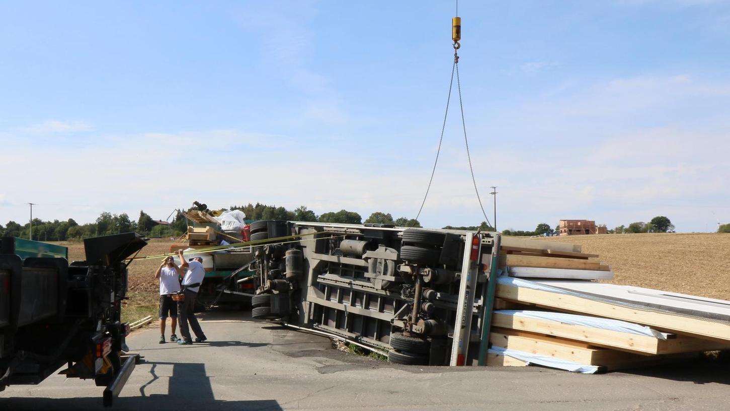 Straße gesperrt: Lastwagen mit Fertighausteilen stürzt um