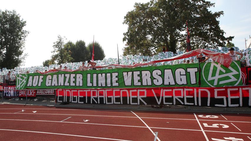 Nach einer kurzen Abkühlung packen die Fans des 1. FC Nürnberg ein Banner mit einer Botschaft in Richtung DFB aus.