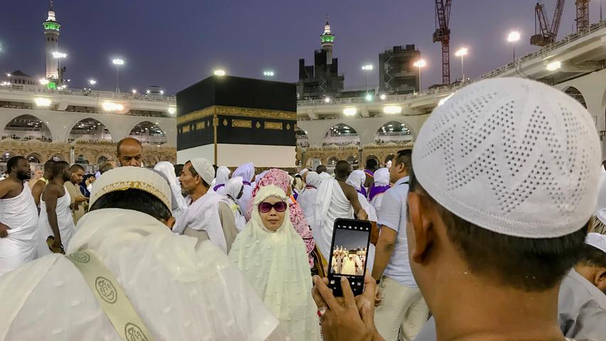 Ein muslimischer Pilger fotografiert vor der Hadsch eine Verwandte in der Nähe der Kaaba.