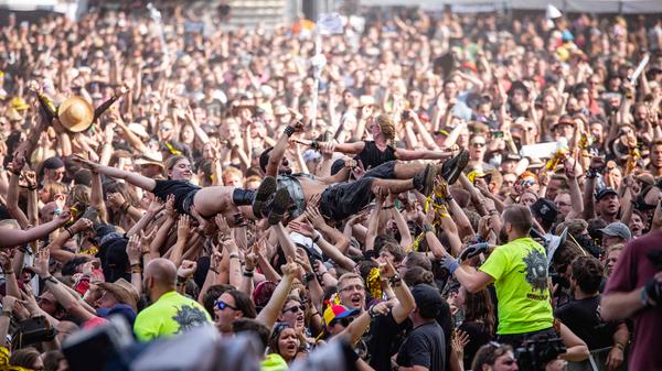 Eine der Lieblingsbeschäftigung der Festivalbesucher ist eindeutig das Crowdsurfen. Nachdem sie wohlbehalten über die Köpfe der Zuschauer hinweg getragen wurden, heben sie die Männer in Neongelb behutsam zu Boden.