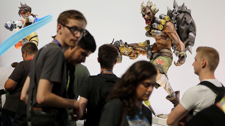 Auf Tuchfühlung mit den Spielfiguren: Besucher der Gamescom warten vor Figuren aus dem Spiel "Overwatch" von Blizzard Entertainment.