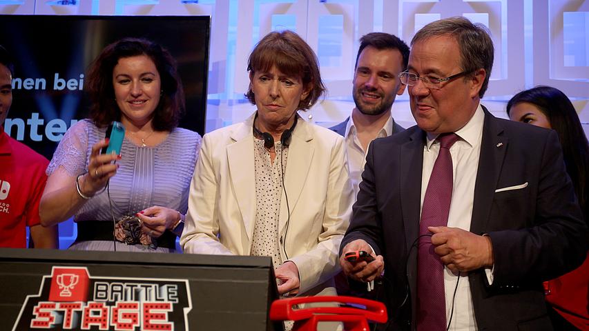Auch die Politik versucht sich im Zocken: Dorothee Bär, Staatsministerin für Digitalisierung (links, CSU), Henriette Reker, Oberbürgermeisterin von Köln (Mitte), und Armin Laschet (rechts, CDU), NRW-Ministerpräsident, spielen auf dem Stand von Nintendo Battle Stage.