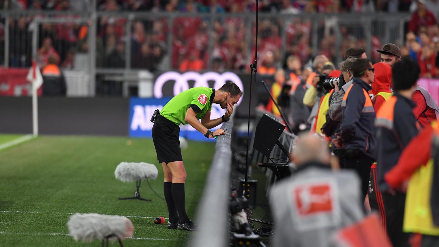 Schiedsrichter Bastian Dankert schaut sich eine Videoaufzeichnung eines Elfmeters für die Bayern an und läßt ihn anschließend wiederholen.