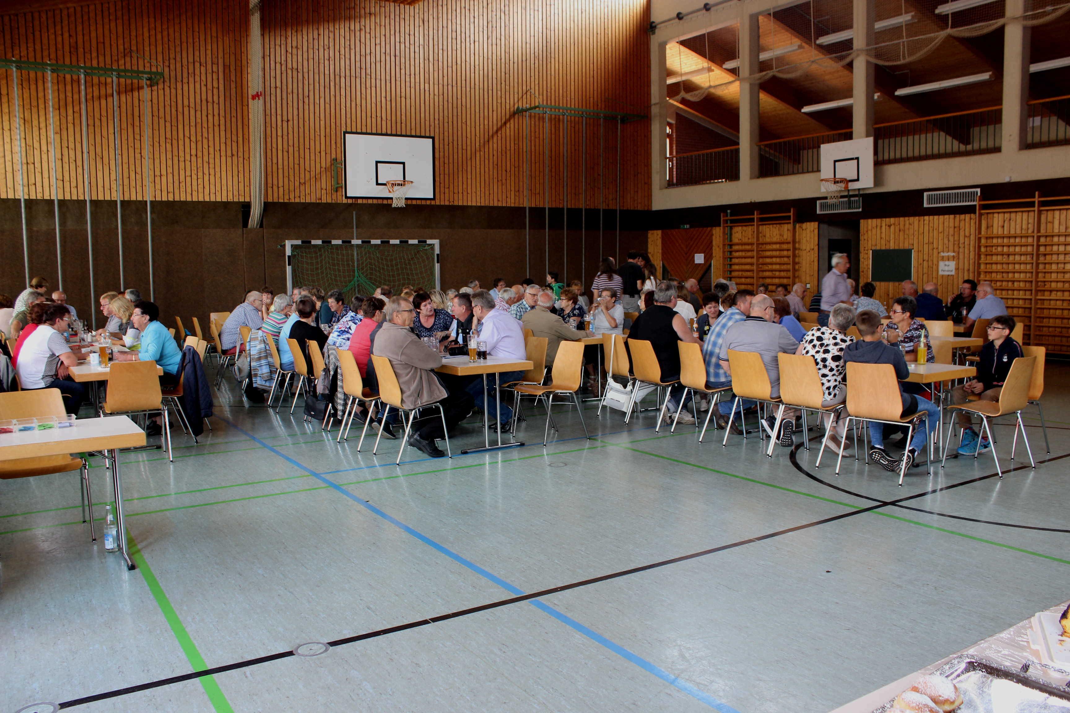 Einmal mehr stellte die VdK-Ortsgruppe Döckingen-Auernheim unter Beweis, dass trotz Terminverschiebung nicht nur die Mitglieder sondern auch die Dorfgemeinschaft beider Orte zu einem Grillfest-Wiederholungstermin gerne kommen. Bei idealem Feierwetter kamen wieder viele Bürger, auch jüngere, in die Döckinger Schulsporthalle. Ferner gehört es mittlerweile zur Tradition, dass der Ortsvorsitzende Siegfried Huber neben den Mitgliedern aus Auernheim und Döckingen auch Mitglieder aus der Kreisvorstandschaft und Kreisgeschäftsstelle herzlich begrüßen durfte. Desweiteren kommen stets gerne die Gruppe „jüngere VdKler“ nach Döckingen um mit zu feiern. Damit aber ein Grillfest gelingen kann, bedarf es den Einsatz und der Mithilfe vieler freiwilliger Helfer am Ausschank, Grill und der Kuchentheke. Dafür zollte Huber seinem Team höchstes Lob, Dank und Anerkennung, denn es hat wieder alles Bestens geklappt.