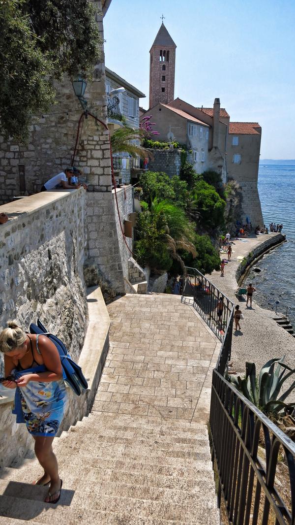 Vor der Stadtmauer geht ein Weg die Klippe hinunter an den Strand.