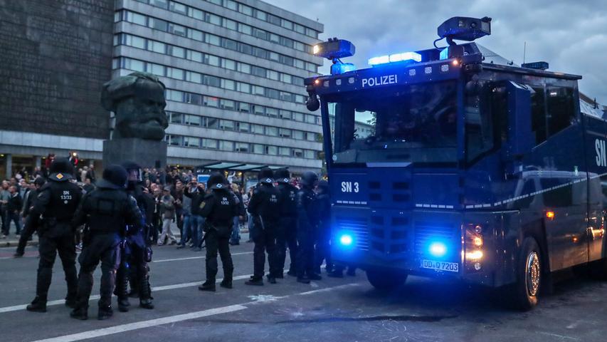 Polizisten sicherten am Montag Demonstranten der rechten Szene vor dem Karl-Marx-Denkmal in Chemnitz mit einem Wasserwerfer.