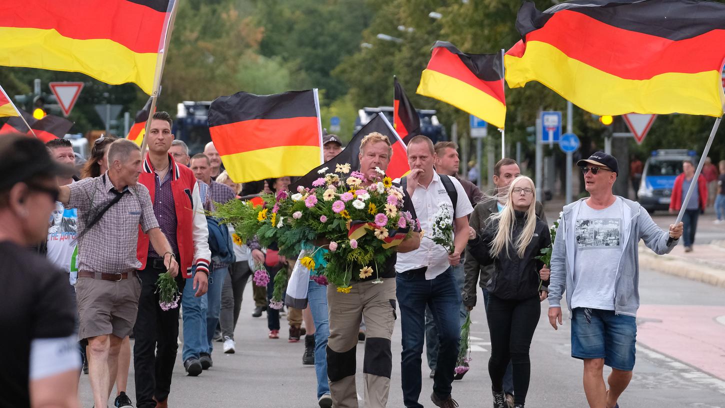 Chemnitz: Blumen werden von einer Gruppe Menschen zum Tatort in der Innenstadt gebracht. Nach einem Streit war hier in der Nacht zu Sonntag ein 35-jähriger Mann erstochen worden. Die Tat war Anlass für spontane Demonstrationen.