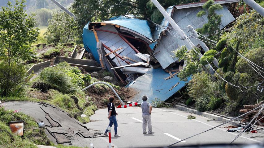 Zerstörte Häuser blockieren nach dem starken Beben im Norden Japans eine Straße. Viele Menschen wurden verletzt, es gab sogar einige Todesopfer.