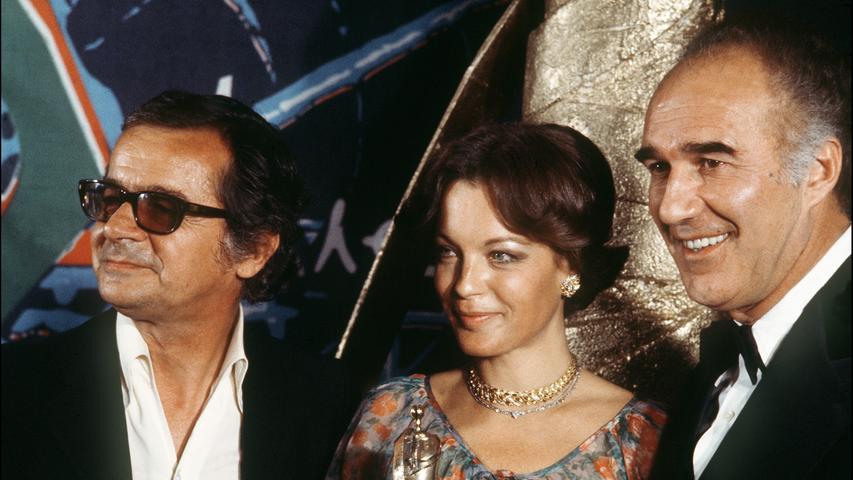 Romy Schneider mit dem Chansonnier und Schauspieler Serge Reggiani (li.) und Michel Piccoli bei der Verleihung der Césars 1976 in Paris. Die Österreicherin wurde damals als beste Hauptdarstellerin für ihre Leistung in 
