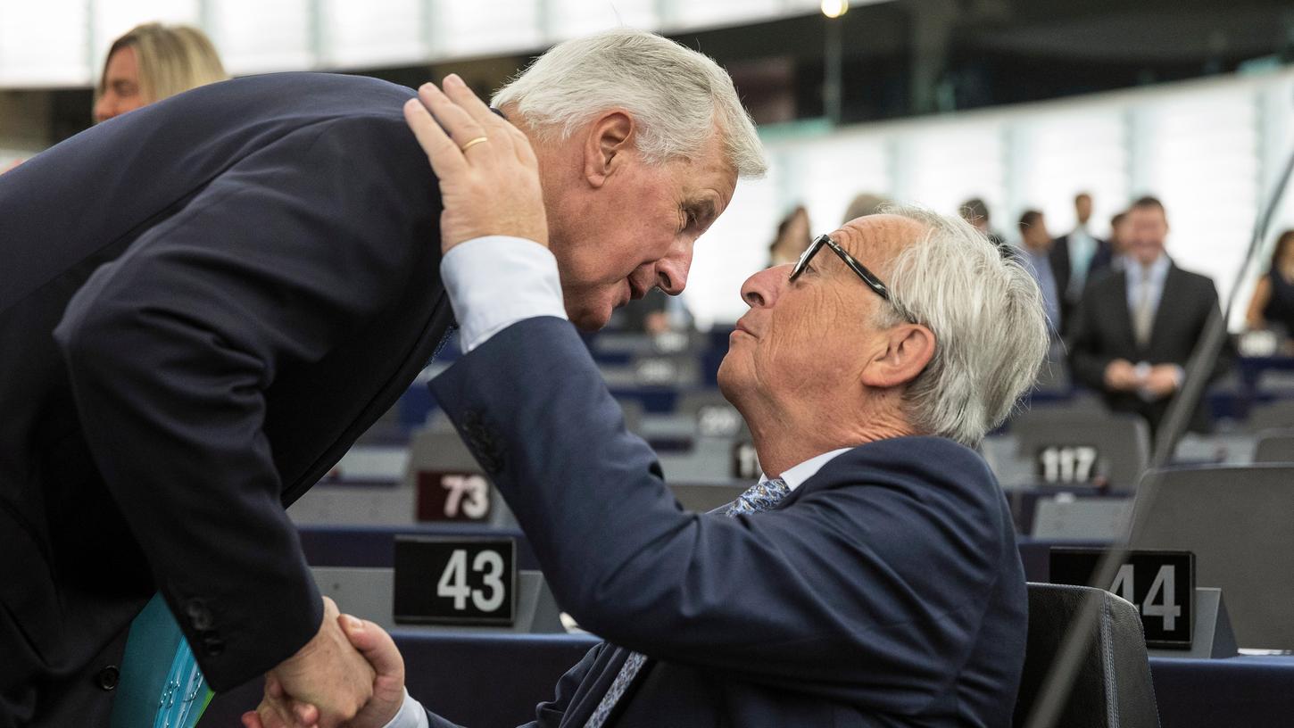 Jean-Claude Juncker (rechts) umarmt im Europäischen Parlament den Brexit-Verhandlungsführer Michel Barnier.