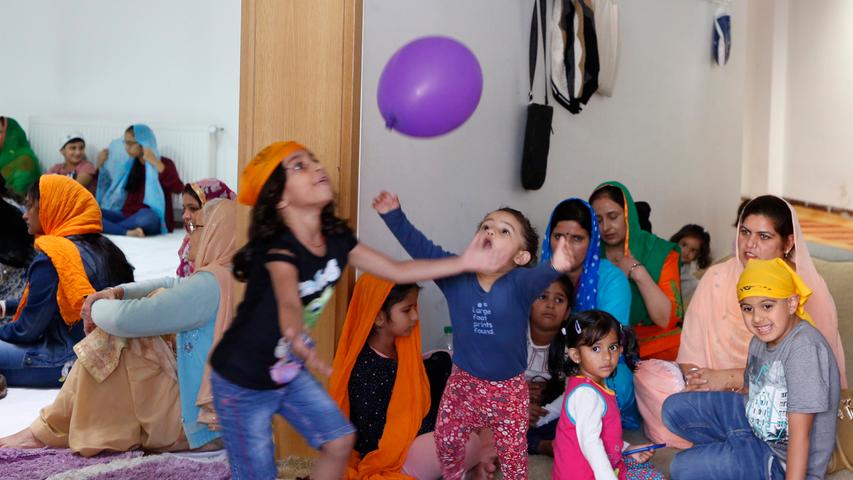 Während des Gottesdiensts der Sikhs spielen manche Kinder lieber mit dem Luftballon.