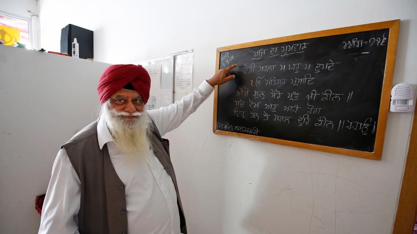 Harminder Pal Singh deutet auf eine Tafel mit Schrift in Panjabi. Die indischen Kinder der fränkischen Sikhs erhalten Unterricht in der Sprache ihrer Vorfahren.