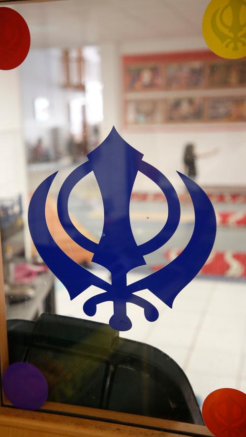 "Khanda", das Zeichen der Sikhs in violett: In der Mitte steht ein Schwert. Darum schließt sich ein Ring als Zeichen für die Unendlichkeit. Dieser wird von zwei weiteren Schwertern umrahmt als Zeichen für spirituelle und weltliche Autorität.