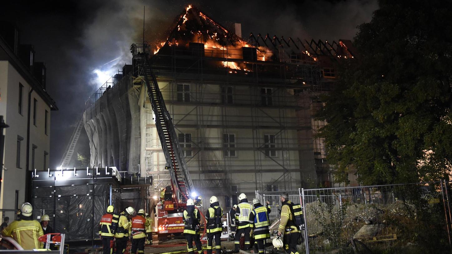 Feuerwehrleute löschen im Bereich des Klosters Rottenbuch den Dachstuhl eines Gebäudes, der in voller Ausdehnung brennt.