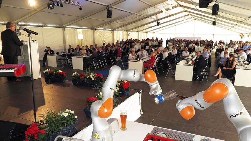 Mit der Einweihung ihres neuen Verwaltungsgebäudes am Hauptsitz in der Treuchtlinger Industriestraße bekannte sich die Firma Alfmeier nicht nur zu ihrem ländlichen Standort, sondern richtete den Blick mit ihrem „Technology Day“ zugleich weit darüber hinaus auf die gesamte Welt sowie den Wandel von Arbeit, Konsum und Gesellschaft im Zeitalter der Digitalisierung. Einen Einblick in die Arbeitsweise im Werk und den Labors gaben zwischen Festakt und Podiumsdiskussion zum Thema „Digitalisierung und die Auswirkungen auf die Arbeitswelt“ mehrere Rundgänge durch das Unternehmen. Dabei gab es auch schon einen Vorgeschmack auf die gerade entstehende „Smart Factory“ in Kooperation mit Siemens. Eine technische Spielerei, die zeigt was möglich ist, waren zwei Roboterarme, die Weißbier einschenkten. Für einen Schreckmoment sorgte das heftige Gewitter, das am späten Nachmittag kurzzeitig drohte, das Festzelt wegzublasen und unter Wasser zu setzen.