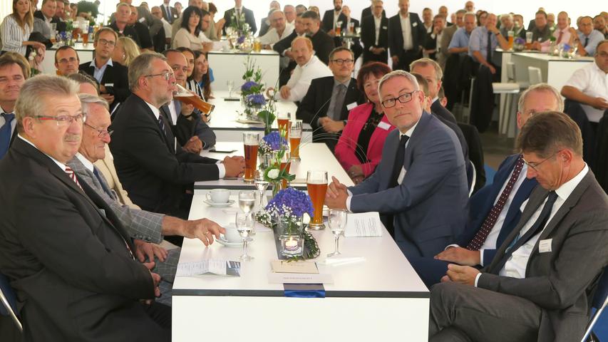 Mit der Einweihung ihres neuen Verwaltungsgebäudes am Hauptsitz in der Treuchtlinger Industriestraße bekannte sich die Firma Alfmeier nicht nur zu ihrem ländlichen Standort, sondern richtete den Blick mit ihrem „Technology Day“ zugleich weit darüber hinaus auf die gesamte Welt sowie den Wandel von Arbeit, Konsum und Gesellschaft im Zeitalter der Digitalisierung. Einen Einblick in die Arbeitsweise im Werk und den Labors gaben zwischen Festakt und Podiumsdiskussion zum Thema „Digitalisierung und die Auswirkungen auf die Arbeitswelt“ mehrere Rundgänge durch das Unternehmen. Dabei gab es auch schon einen Vorgeschmack auf die gerade entstehende „Smart Factory“ in Kooperation mit Siemens. Eine technische Spielerei, die zeigt was möglich ist, waren zwei Roboterarme, die Weißbier einschenkten. Für einen Schreckmoment sorgte das heftige Gewitter, das am späten Nachmittag kurzzeitig drohte, das Festzelt wegzublasen und unter Wasser zu setzen.