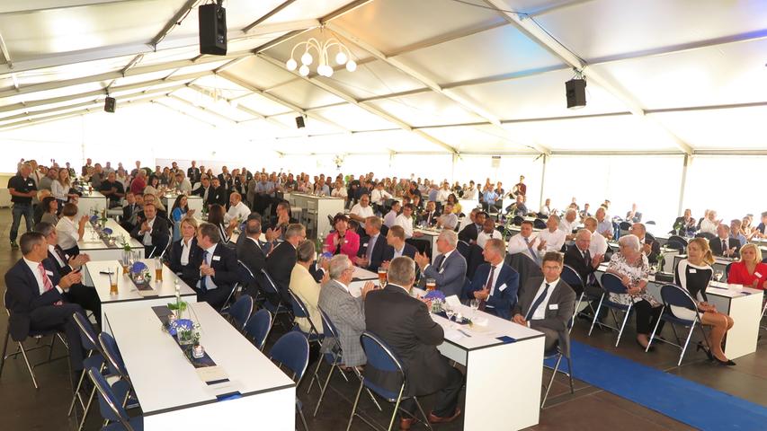 Mit der Einweihung ihres neuen Verwaltungsgebäudes am Hauptsitz in der Treuchtlinger Industriestraße bekannte sich die Firma Alfmeier nicht nur zu ihrem ländlichen Standort, sondern richtete den Blick mit ihrem „Technology Day“ zugleich weit darüber hinaus auf die gesamte Welt sowie den Wandel von Arbeit, Konsum und Gesellschaft im Zeitalter der Digitalisierung. Einen Einblick in die Arbeitsweise im Werk und den Labors gaben zwischen Festakt und Podiumsdiskussion zum Thema „Digitalisierung und die Auswirkungen auf die Arbeitswelt“ mehrere Rundgänge durch das Unternehmen. Dabei gab es auch schon einen Vorgeschmack auf die gerade entstehende „Smart Factory“ in Kooperation mit Siemens. Eine technische Spielerei, die zeigt was möglich ist, waren zwei Roboterarme, die Weißbier einschenkten. Für einen Schreckmoment sorgte das heftige Gewitter, das am späten Nachmittag kurzzeitig drohte, das Festzelt wegzublasen und unter Wasser zu setzen.