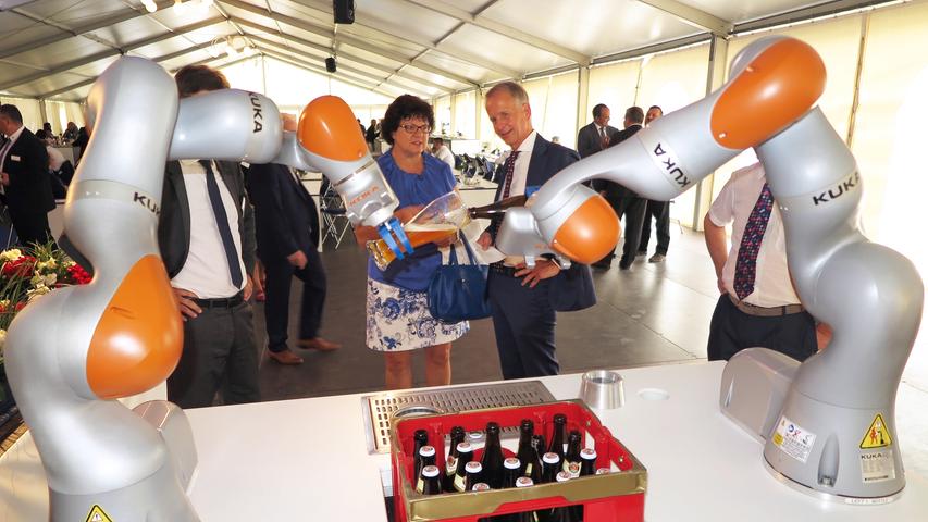 Mit der Einweihung ihres neuen Verwaltungsgebäudes am Hauptsitz in der Treuchtlinger Industriestraße bekannte sich die Firma Alfmeier nicht nur zu ihrem ländlichen Standort, sondern richtete den Blick mit ihrem „Technology Day“ zugleich weit darüber hinaus auf die gesamte Welt sowie den Wandel von Arbeit, Konsum und Gesellschaft im Zeitalter der Digitalisierung. Einen Einblick in die Arbeitsweise im Werk und den Labors gaben zwischen Festakt und Podiumsdiskussion zum Thema „Digitalisierung und die Auswirkungen auf die Arbeitswelt“ mehrere Rundgänge durch das Unternehmen. Dabei gab es auch schon einen Vorgeschmack auf die gerade entstehende „Smart Factory“ in Kooperation mit Siemens. Eine technische Spielerei, die zeigt was möglich ist, waren zwei Roboterarme, die Weißbier einschenkten. Für einen Schreckmoment sorgte das heftige Gewitter, das am späten Nachmittag kurzzeitig drohte, das Festzelt wegzublasen und unter Wasser zu setzen. Mit der Einweihung ihres neuen Verwaltungsgebäudes am Hauptsitz in der Treuchtlinger Industriestraße bekannte sich die Firma Alfmeier nicht nur zu ihrem ländlichen Standort, sondern richtete den Blick mit ihrem „Technology Day“ zugleich weit darüber hinaus auf die gesamte Welt sowie den Wandel von Arbeit, Konsum und Gesellschaft im Zeitalter der Digitalisierung. Einen Einblick in die Arbeitsweise im Werk und den Labors gaben zwischen Festakt und Podiumsdiskussion zum Thema „Digitalisierung und die Auswirkungen auf die Arbeitswelt“ mehrere Rundgänge durch das Unternehmen. Dabei gab es auch schon einen Vorgeschmack auf die gerade entstehende „Smart Factory“ in Kooperation mit Siemens. Eine technische Spielerei, die zeigt was möglich ist, waren zwei Roboterarme, die Weißbier einschenkten. Für einen Schreckmoment sorgte das heftige Gewitter, das am späten Nachmittag kurzzeitig drohte, das Festzelt wegzublasen und unter Wasser zu setzen.