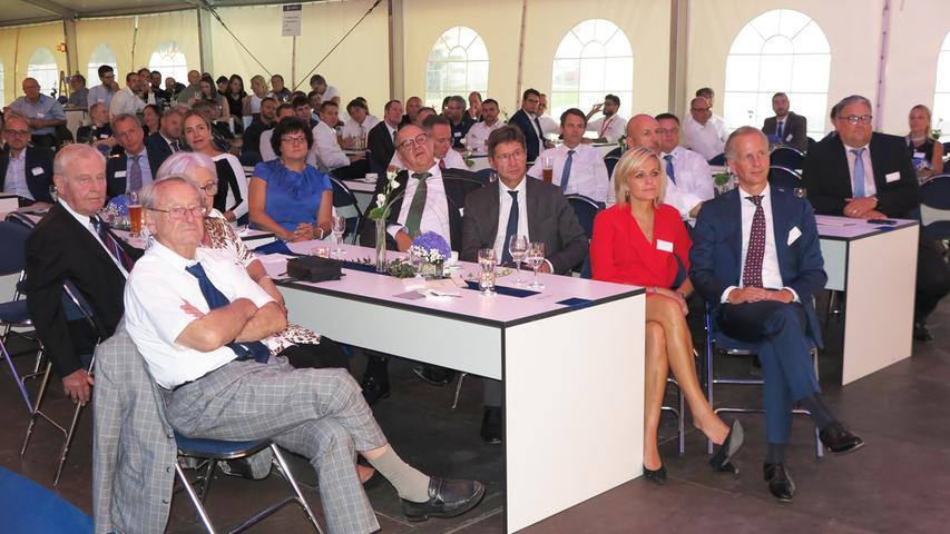 Mit der Einweihung ihres neuen Verwaltungsgebäudes am Hauptsitz in der Treuchtlinger Industriestraße bekannte sich die Firma Alfmeier nicht nur zu ihrem ländlichen Standort, sondern richtete den Blick mit ihrem „Technology Day“ zugleich weit darüber hinaus auf die gesamte Welt sowie den Wandel von Arbeit, Konsum und Gesellschaft im Zeitalter der Digitalisierung. Einen Einblick in die Arbeitsweise im Werk und den Labors gaben zwischen Festakt und Podiumsdiskussion zum Thema „Digitalisierung und die Auswirkungen auf die Arbeitswelt“ mehrere Rundgänge durch das Unternehmen. Dabei gab es auch schon einen Vorgeschmack auf die gerade entstehende „Smart Factory“ in Kooperation mit Siemens. Eine technische Spielerei, die zeigt was möglich ist, waren zwei Roboterarme, die Weißbier einschenkten. Für einen Schreckmoment sorgte das heftige Gewitter, das am späten Nachmittag kurzzeitig drohte, das Festzelt wegzublasen und unter Wasser zu setzen. Mit der Einweihung ihres neuen Verwaltungsgebäudes am Hauptsitz in der Treuchtlinger Industriestraße bekannte sich die Firma Alfmeier nicht nur zu ihrem ländlichen Standort, sondern richtete den Blick mit ihrem „Technology Day“ zugleich weit darüber hinaus auf die gesamte Welt sowie den Wandel von Arbeit, Konsum und Gesellschaft im Zeitalter der Digitalisierung. Einen Einblick in die Arbeitsweise im Werk und den Labors gaben zwischen Festakt und Podiumsdiskussion zum Thema „Digitalisierung und die Auswirkungen auf die Arbeitswelt“ mehrere Rundgänge durch das Unternehmen. Dabei gab es auch schon einen Vorgeschmack auf die gerade entstehende „Smart Factory“ in Kooperation mit Siemens. Eine technische Spielerei, die zeigt was möglich ist, waren zwei Roboterarme, die Weißbier einschenkten. Für einen Schreckmoment sorgte das heftige Gewitter, das am späten Nachmittag kurzzeitig drohte, das Festzelt wegzublasen und unter Wasser zu setzen.