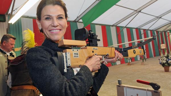 Marion Kiechle, bayerische Ministerin für Kunst und Wissenschaft (CSU), schießt auf dem Oktoberfest scharf. Mit der Armbrust posiert sie im Schützenzelt.