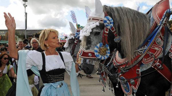 Auch Schauspielerin Uschi Glas hat auf der Damenwiesn beim Schützenzelt ihr Herz für große Rösser entdeckt. Das Pferd bleibt trotz wilder Gesten und Menschenauflauf aber unbeeindruckt.