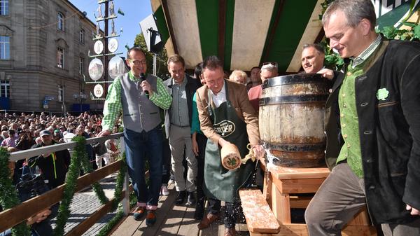Und schon holt Oberbürgermeister Thomas Jung zum Schlag aus. Eins, zwei, drei und Angstochen is! Das Bier spritzt in alle Richtungen.