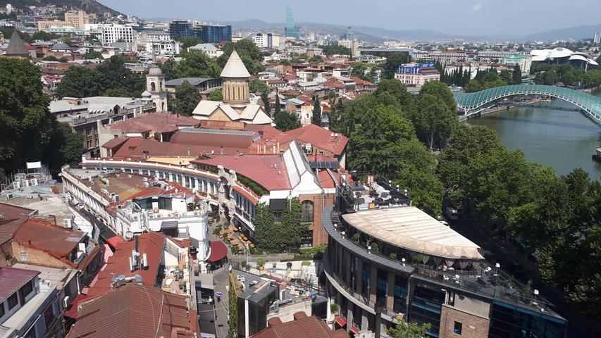 Eine Stadtimpression, aufgenommen aus der Gondel zur Festung von Tiflis. Die moderne Fußgängerbrücke zum Rike-Park stammt, wie viele moderne Bauten, aus der Ära des Präsidenten Saakaschwili.