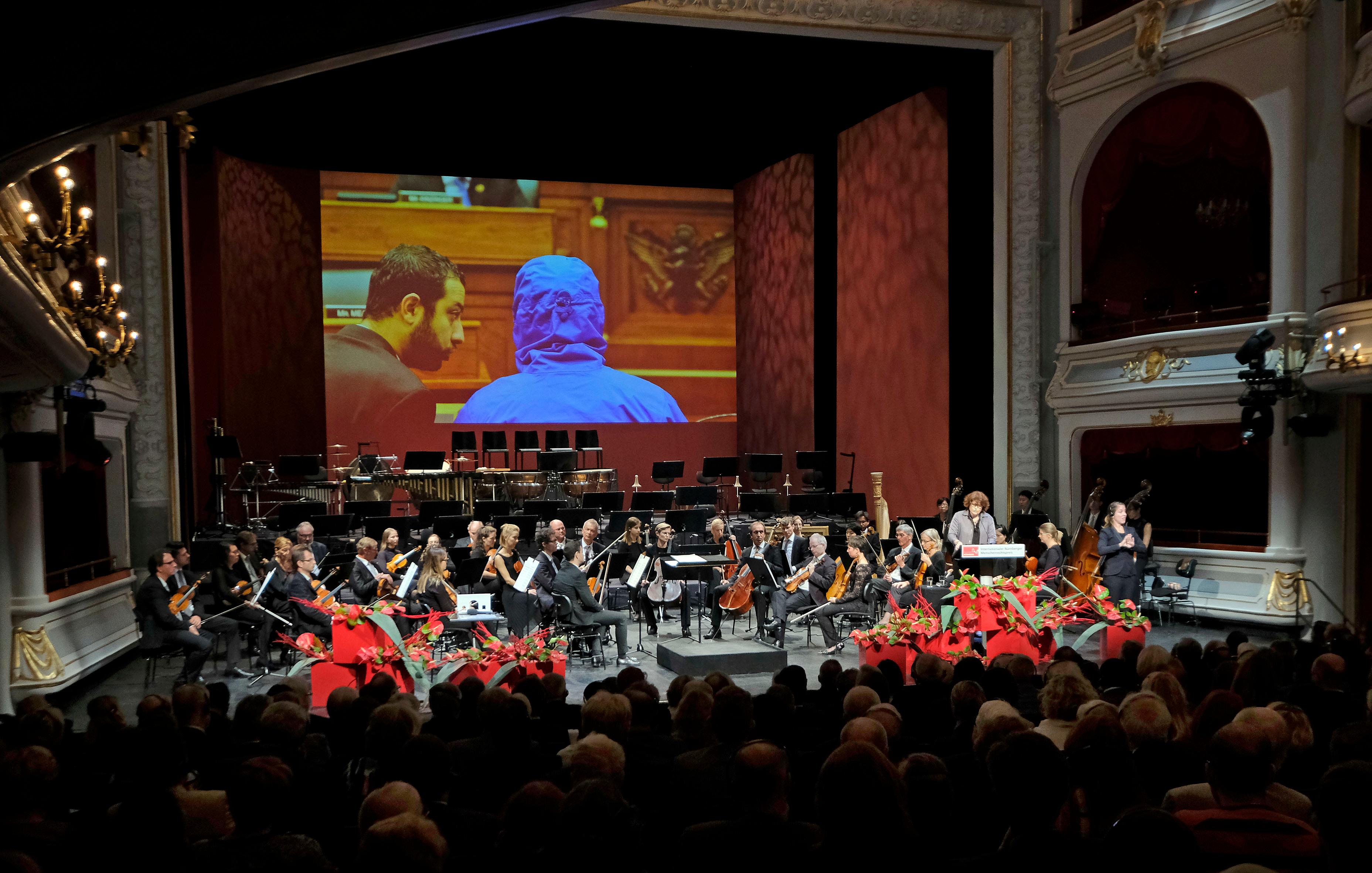 Die französische Journalistin Garance Le Caisne nahm vor einem Jahr stellvertretend für "Caesar" den Menschenrechtspreis von Nürnbergs Oberbürgermeister Maly und dem langjährigen Jurymitglied Dani Karavan entgegen. Der ehemalige syrische Militärfotograf mit dem Decknamen "Caesar" schmuggelte mit Freunden Fotos außer Landes, die die Menschenrechtsverletzungen und den Massenmord in Syrien dokumentieren. Das Fotografieren der Folter- und Mordopfer war der grässliche Berufsalltag "Caesars". In Gefängnissen des Assad-Regimes musste er die Opfer des syrischen Staatsterrors akribisch dokumentieren. 28.000 Bilder von mindestens 6700 toten Gefangenen entstanden zwischen 2011 und 2013 und dienen mittlerweile als Beweismaterialien vor Gerichtsverfahren wegen Kriegsverbrechen.
