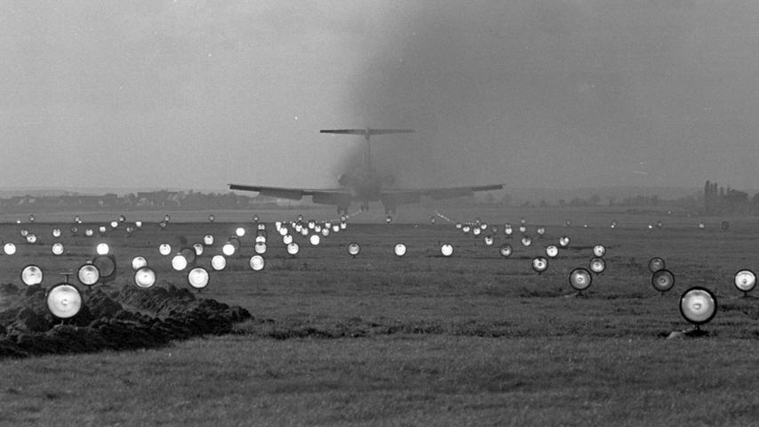 Hübscher Lichtzauber auf dem Nürnberger Flughafen: scheinbar wahllos über das Gelände verstreut leuchten die zahlreichen Lampen in weißer, roter und grüner Farbe. Doch dem Piloten der großen Düsenmaschine sind sie wichtige Orientierungshilfen beim Landen. Hier geht es zum Kalenderblatt vom 30. Oktober 1968: Piloten reden kaum vom Wetter