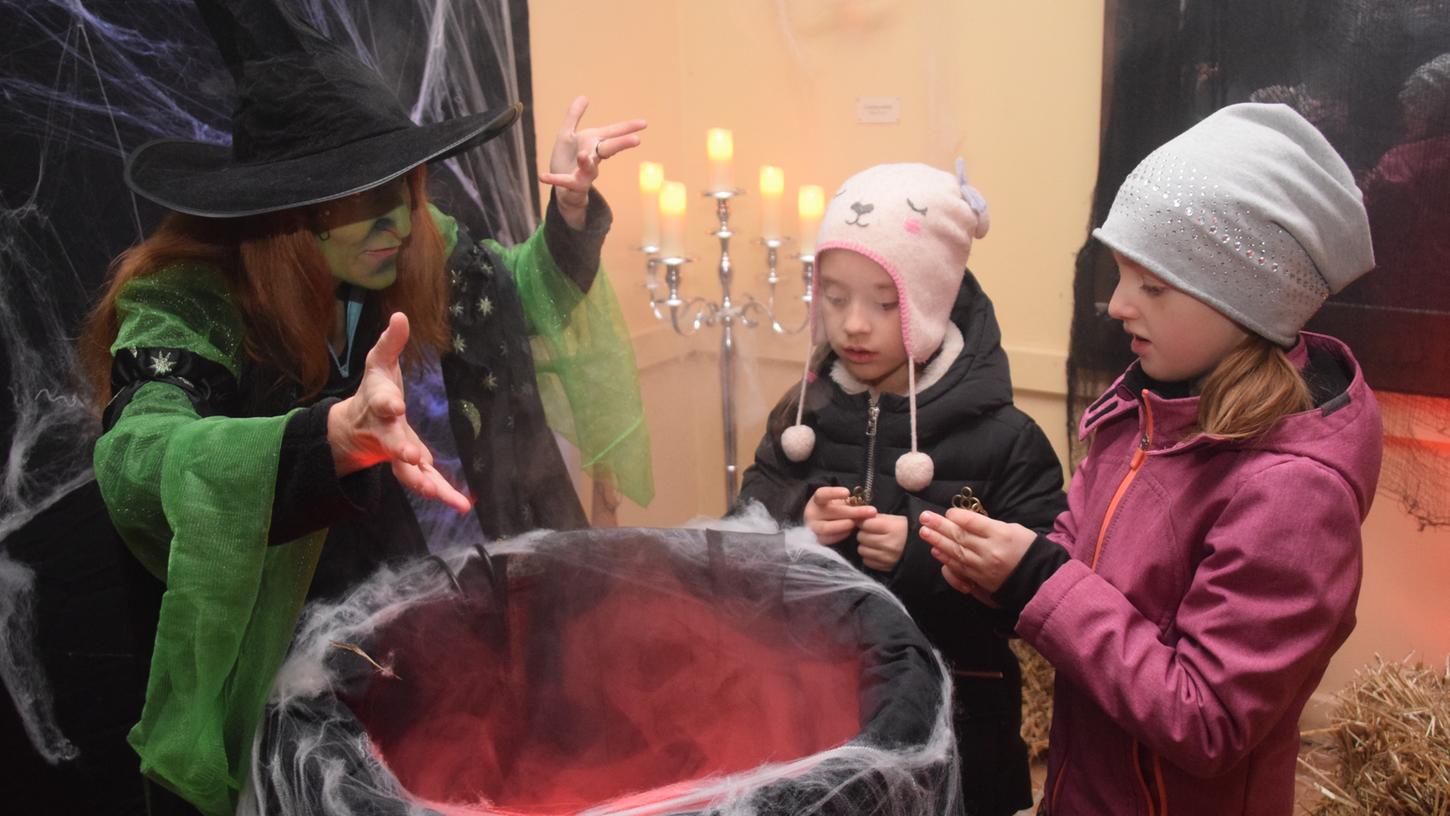 Halloween hautnah: Während die Hexe in ihrem Kessel rührt, schauen die Kinder aufmerksam zu.