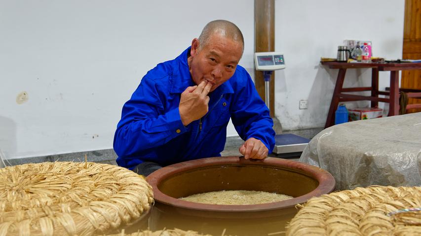Reisweinmeister Guanxian Wang testet den Stand der Vergärung seines Reisweines.
