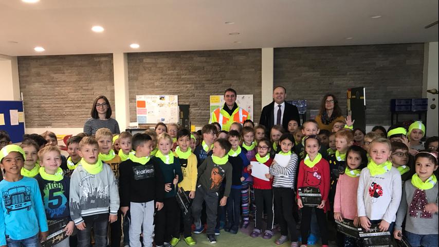 Passend zu Beginn der dunklen Jahreszeit, besuchten die Treuchtlinger Sparkassenmitarbeiterin Andrea Obernöder und Filialdirektor Ralf Lenik die Grundschule Treuchtlingen und hatten für die Erstklässler eine Überraschung im Gepäck. Da der Sparkasse Mittelfranken-Süd die Sicherheit unserer jüngsten Verkehrsteilnehmer sehr am Herzen liegt, werden von den Mitarbeitern jedes Jahr an alle ersten Klassen im Geschäftsgebiet neongelbe Schlauchtücher verteilt. Die reflektierende Schutzkleidung ist nicht nur modisch ein Hingucker, sondern soll vor allem dafür sorgen, dass die Kinder von anderen Verkehrsteilnehmern besser gesehen werden. Mit den „Kleinen“ freuten sich Lehrerin Frau Eichmüller, Verkehrspolizist Hilmar Jung, Ralf Lenik sowie Andrea Obernöder von der Sparkasse (von links). Passend zu Beginn der dunklen Jahreszeit, besuchten die Treuchtlinger Sparkassenmitarbeiterin Andrea Obernöder und Filialdirektor Ralf Lenik die Grundschule Treuchtlingen und hatten für die Erstklässler eine Überraschung im Gepäck. Da der Sparkasse Mittelfranken-Süd die Sicherheit unserer jüngsten Verkehrsteilnehmer sehr am Herzen liegt, werden von den Mitarbeitern jedes Jahr an alle ersten Klassen im Geschäftsgebiet neongelbe Schlauchtücher verteilt. Die reflektierende Schutzkleidung ist nicht nur modisch ein Hingucker, sondern soll vor allem dafür sorgen, dass die Kinder von anderen Verkehrsteilnehmern besser gesehen werden. Mit den „Kleinen“ freuten sich Lehrerin Frau Eichmüller, Verkehrspolizist Hilmar Jung, Ralf Lenik sowie Andrea Obernöder von der Sparkasse (von links).