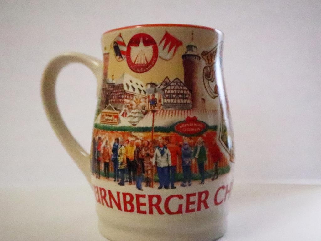 Die Tasse des Jahres 2018 war in den vergangenen Jahren wohl die Bunteste. In den darauffolgenden Jahren hielten sich die Designer mit den Farben eher zurück. 2018 hingegen zeigte das Motiv bunt gekleidete Besucherinnen und Besucher vor den Buden. Das Innere der Tasse erstrahlte - sofern nicht mit weißem oder rotem Glühwein gefüllt - in prächtigem Orange. Die Tasse des Jahres 2018 war in den vergangenen Jahren wohl die Bunteste. In den darauffolgenden Jahren hielten sich die Designer mit den Farben eher zurück. 2018 hingegen zeigte das Motiv bunt gekleidete Besucherinnen und Besucher vor den Buden. Das Innere der Tasse erstrahlte - sofern nicht mit weißem oder rotem Glühwein gefüllt - in prächtigem Orange.