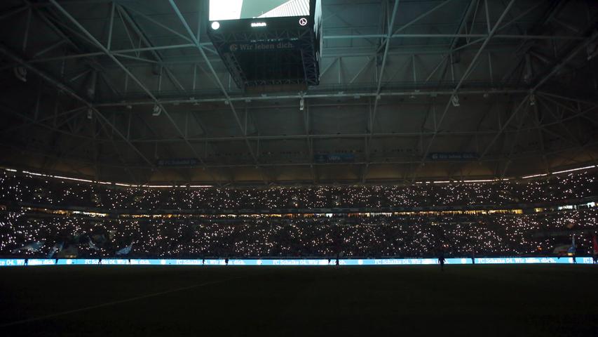 Vor dem Anpfiff und pünktlich zum Steigerlied gehen in der Veltins-Arena die Lichter aus. Die Zuschauer zücken ihre Handys und bringen das Stadion zum leuchten.