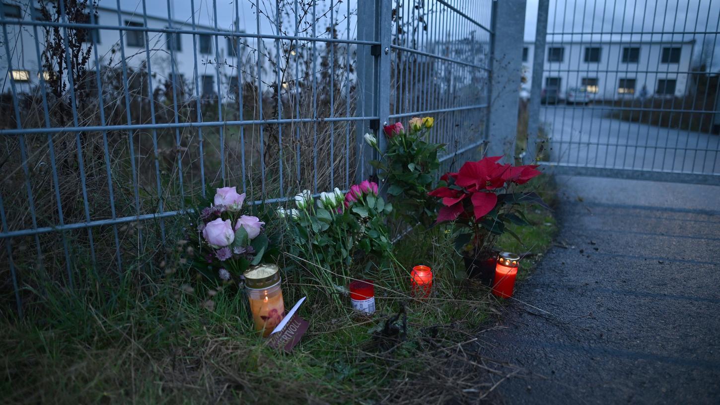 Blumen und Kerzen stehen am Eingang zu einer kommunalen Unterkunft, in der neben Flüchtlingen auch Obdachlose untergebracht sind.