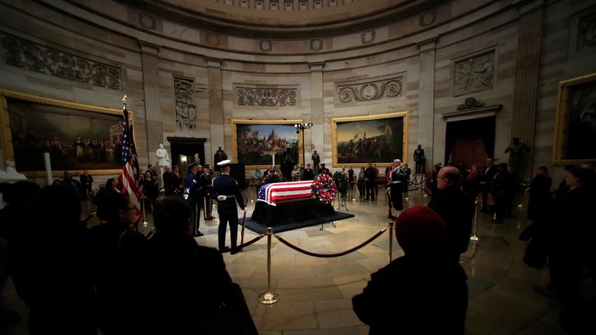 Trauernde stehen an dem mit einer Flagge verhüllten Sarg des ehemaligen US-Präsidenten George H.W. Bush, der vor der Trauerfeier in der Rotunde des U.S. Kapitols aufgebahrt war.